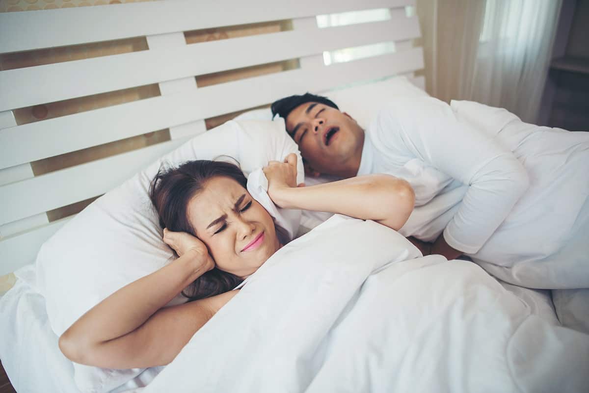woman sleeping with her snoring partner