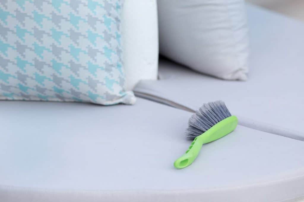 Brushing Dust Off before Spot Cleaning a Pillow