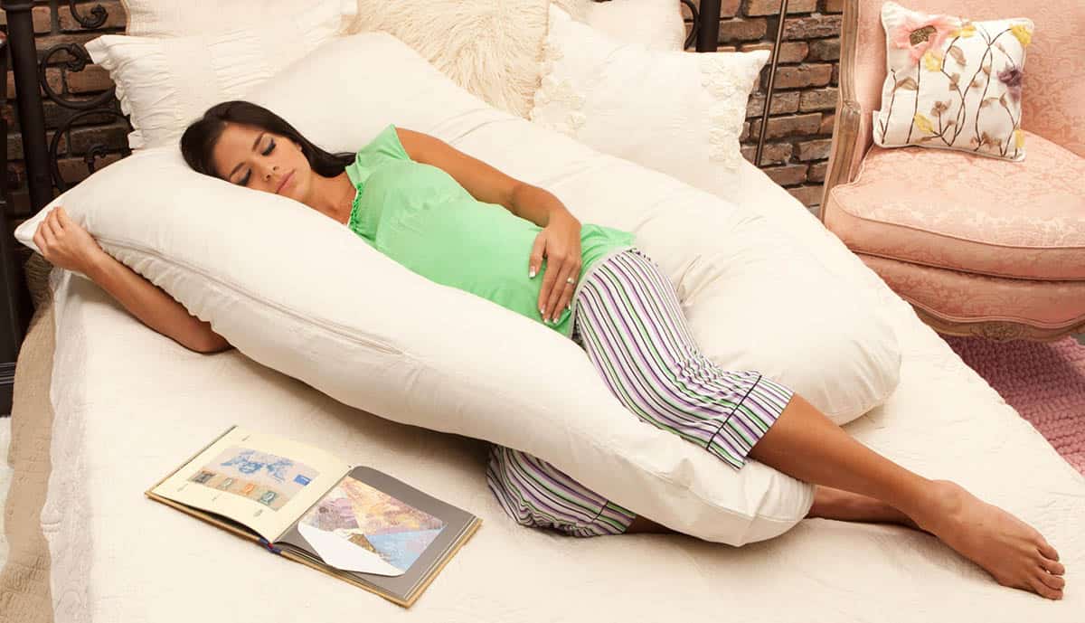 pregnant woman sleeping with a body pillow
