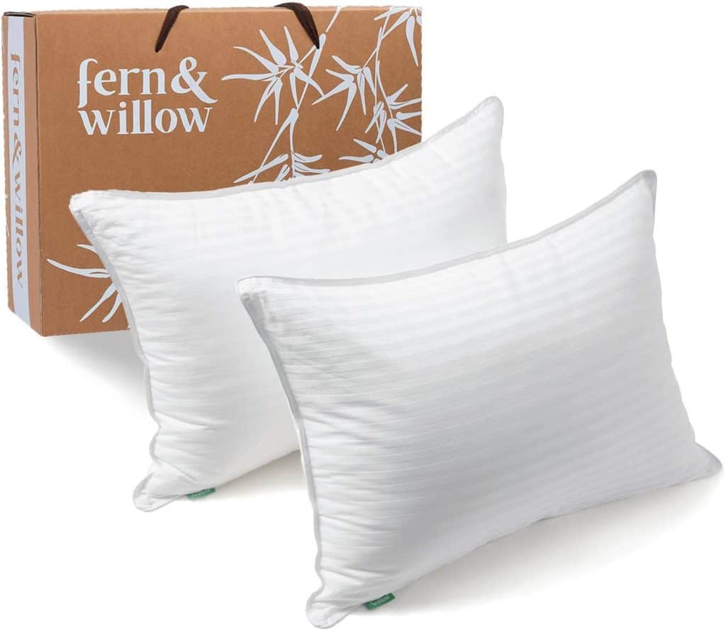 Two down alternative pillows stand in front of a brown fern and willow box
