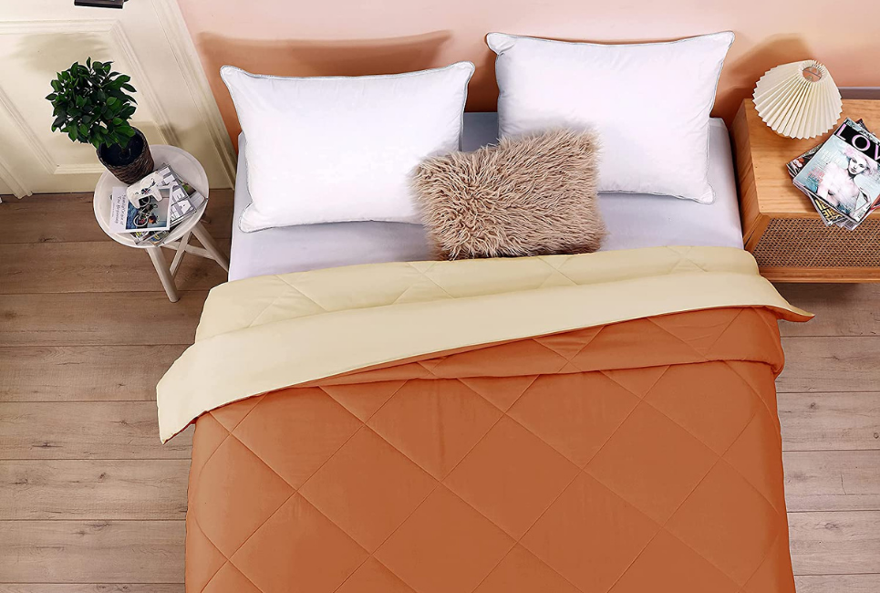 orange comforter on trendy bed