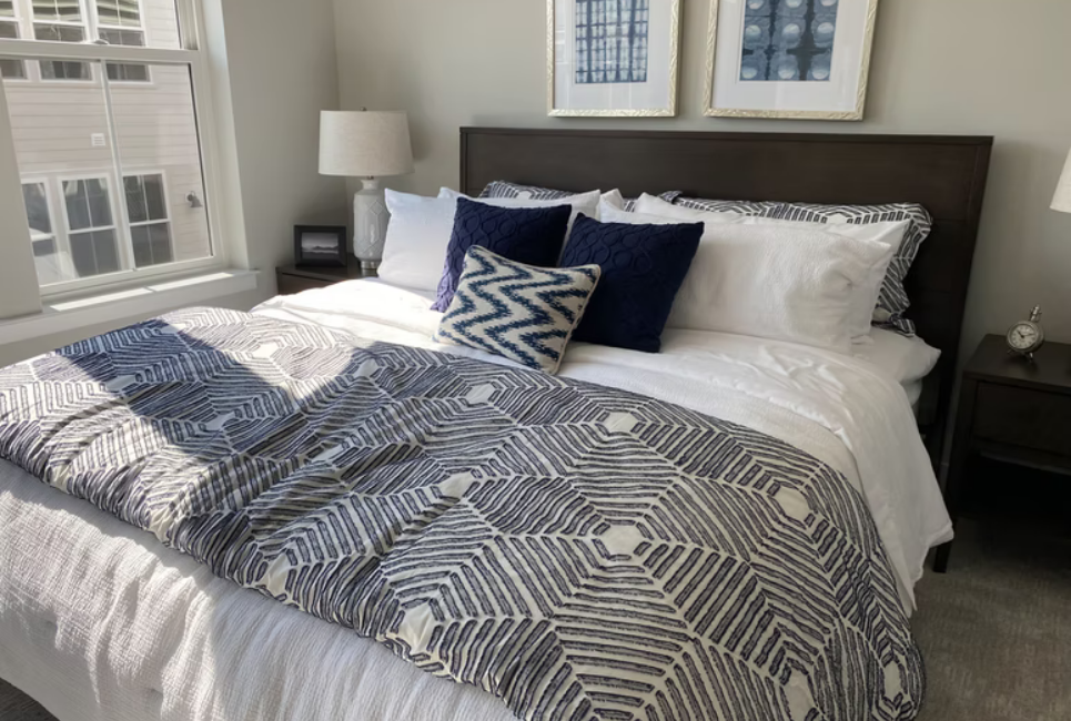 bed made with geometric blue and white bedding