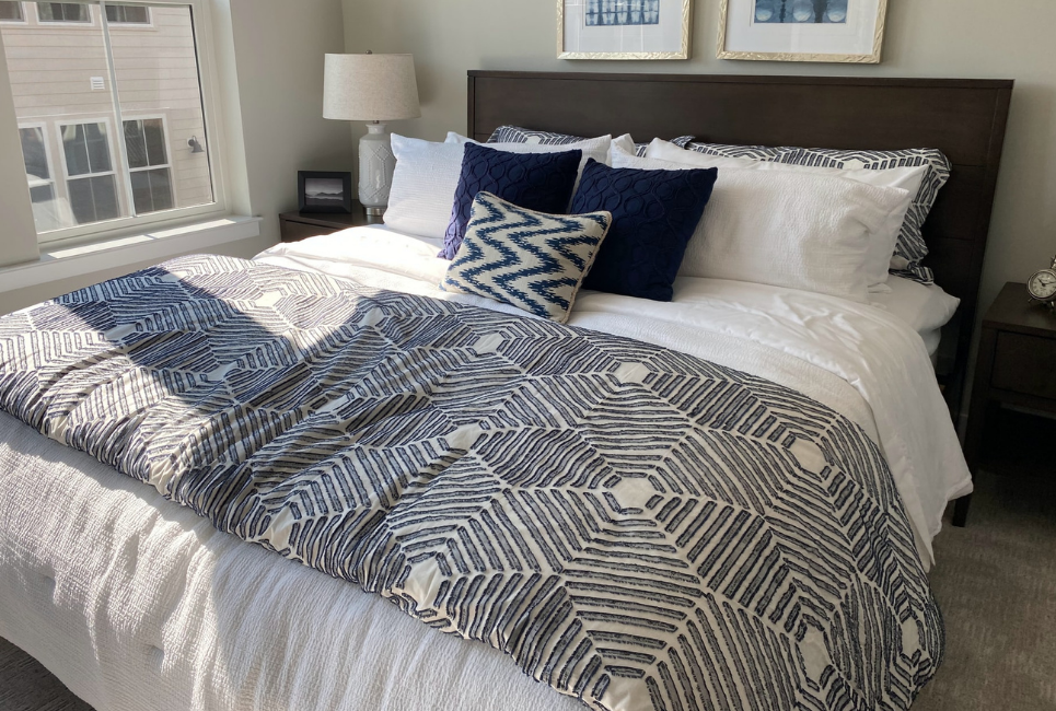 king sized bed with geometric navy and white bedding
