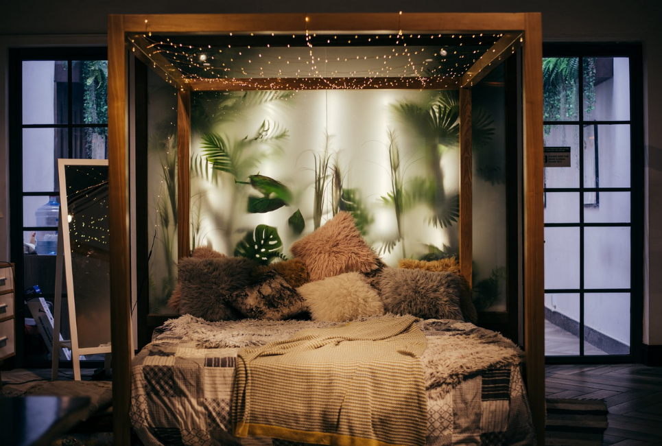 trendy boho canopy bed with throw pillows and fairy lights