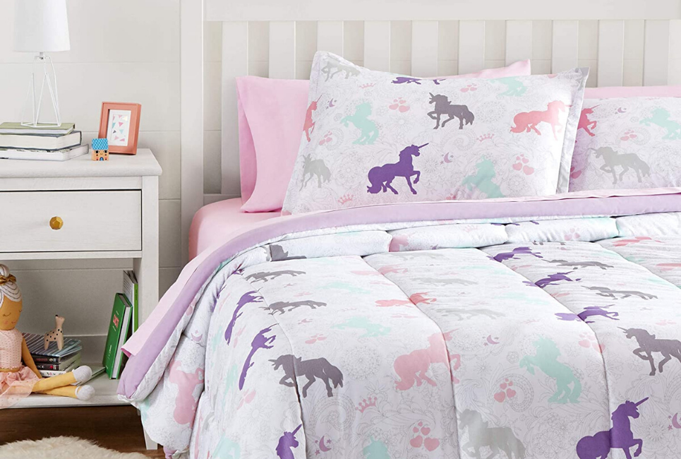 unicorn comforter on bed with pink sheets