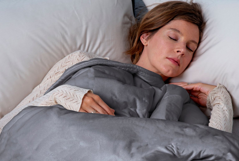 woman sleeping peacefully under grey soft blanket