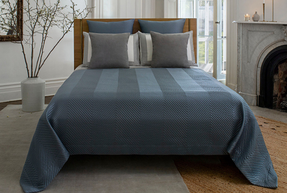 bed made neatly with blue striped bedding