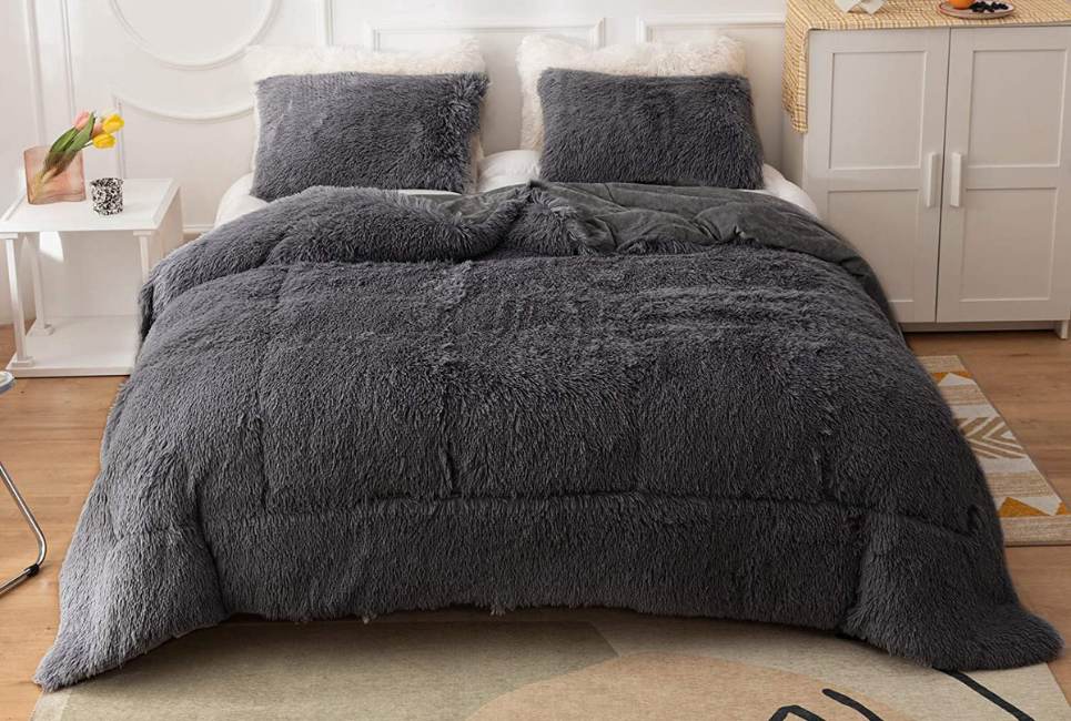 grey faux fur comforter on bed in clean room
