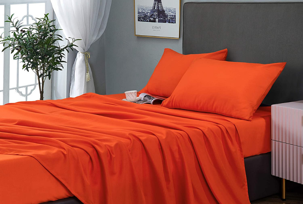 bed in modern trendy room with orange sheets