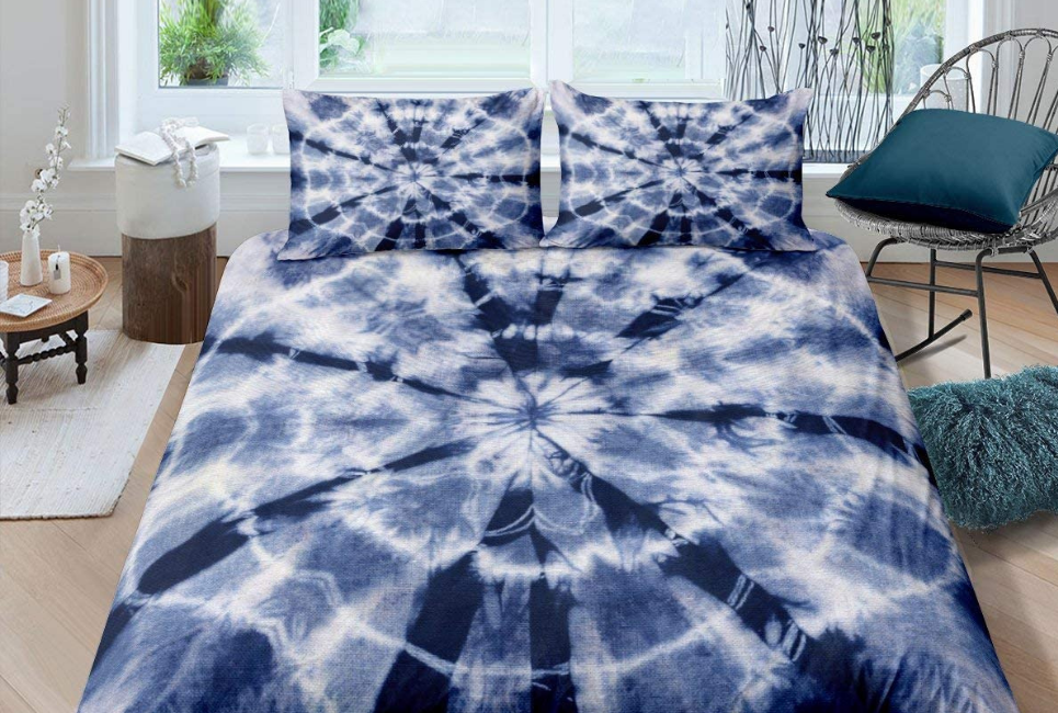 Blue tie dyed bedding set on neatly made bed