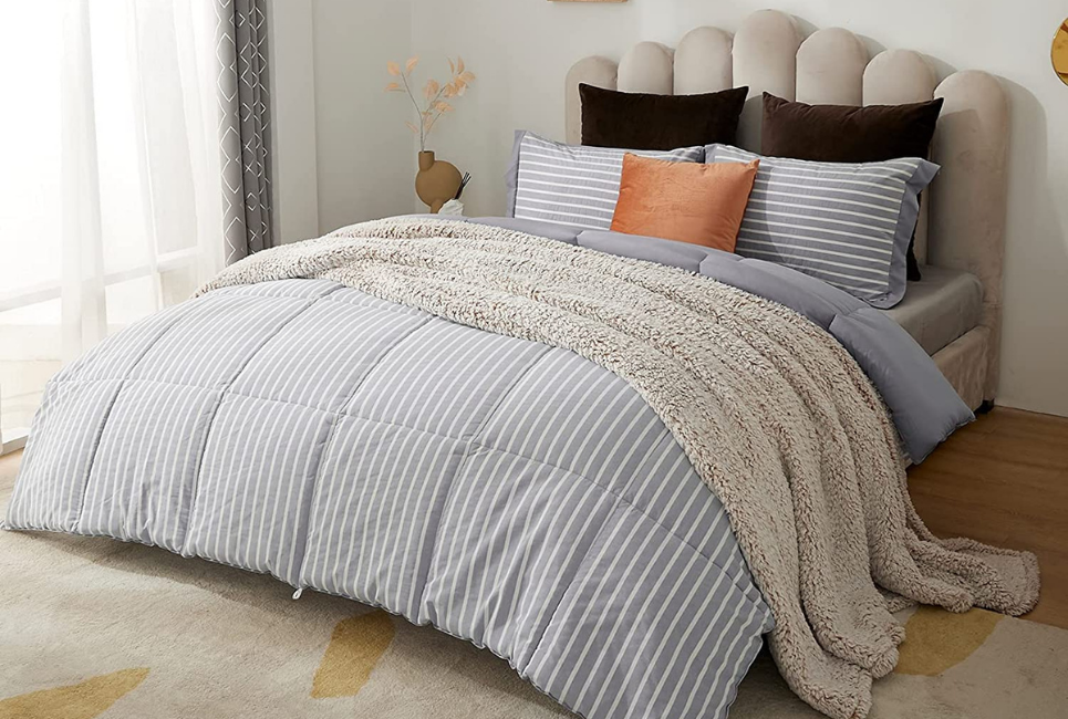 neatly made trendy bed with grey striped comforter