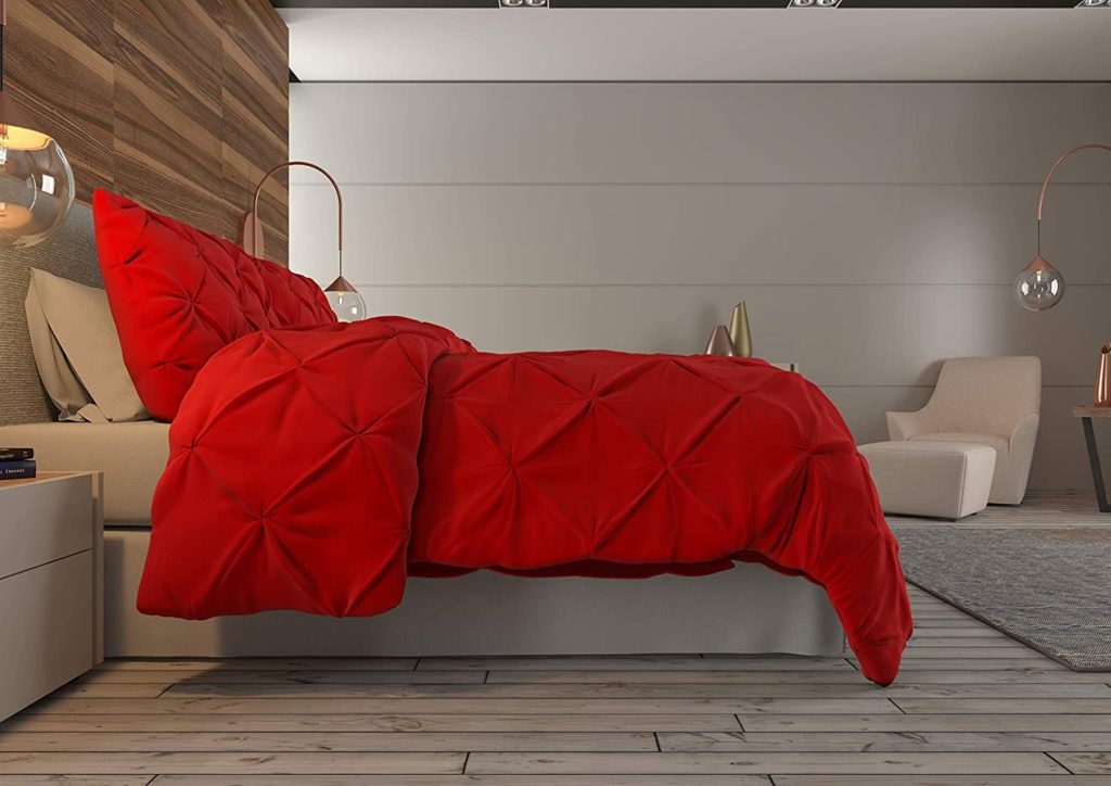red pintuck bedding on bed in room shown from the side