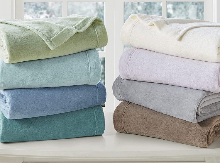 4 different colors of fleece blankets stacked