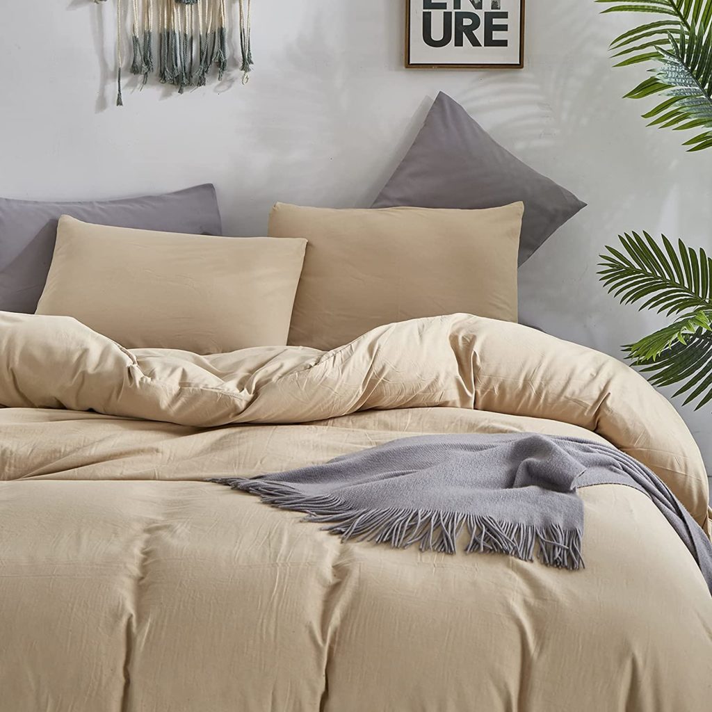 Beige comforter and bedding styled in neutral decorated room