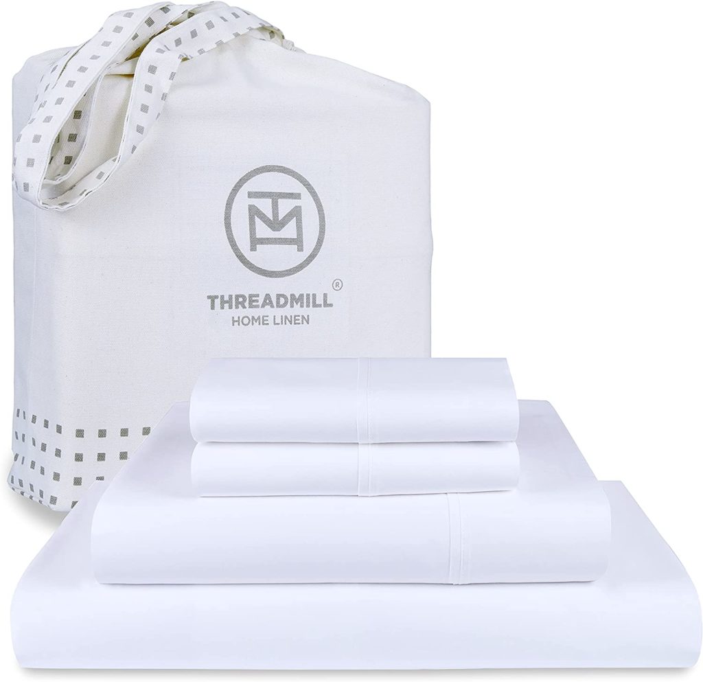 White Cotton Sheets folded neatly with packaging behind it that reads "Threadmill Home Linen"