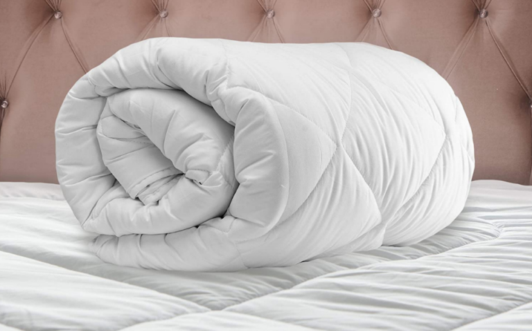 cream white comforter neatly rolled up on bed
