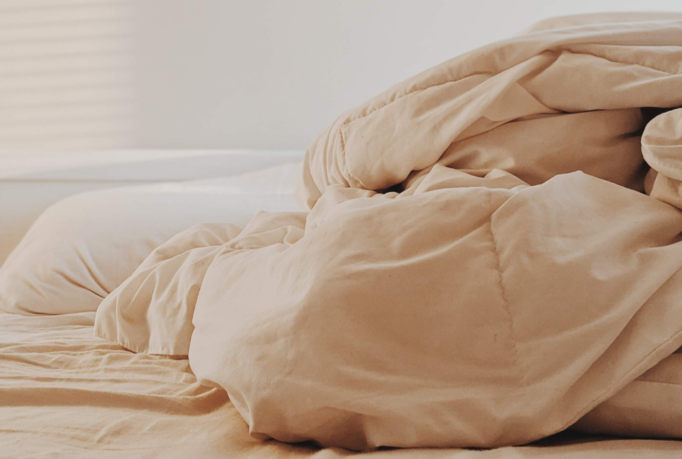 beige comforter piled up on bed