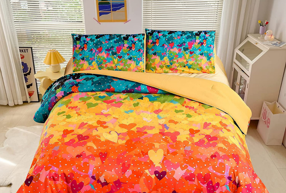 multicolored heart print rainbow comforter on bed