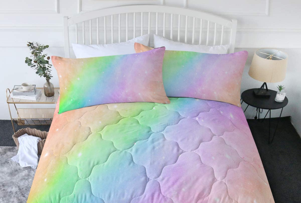 multicolored pastel comforter on bed with subtle white starbursts