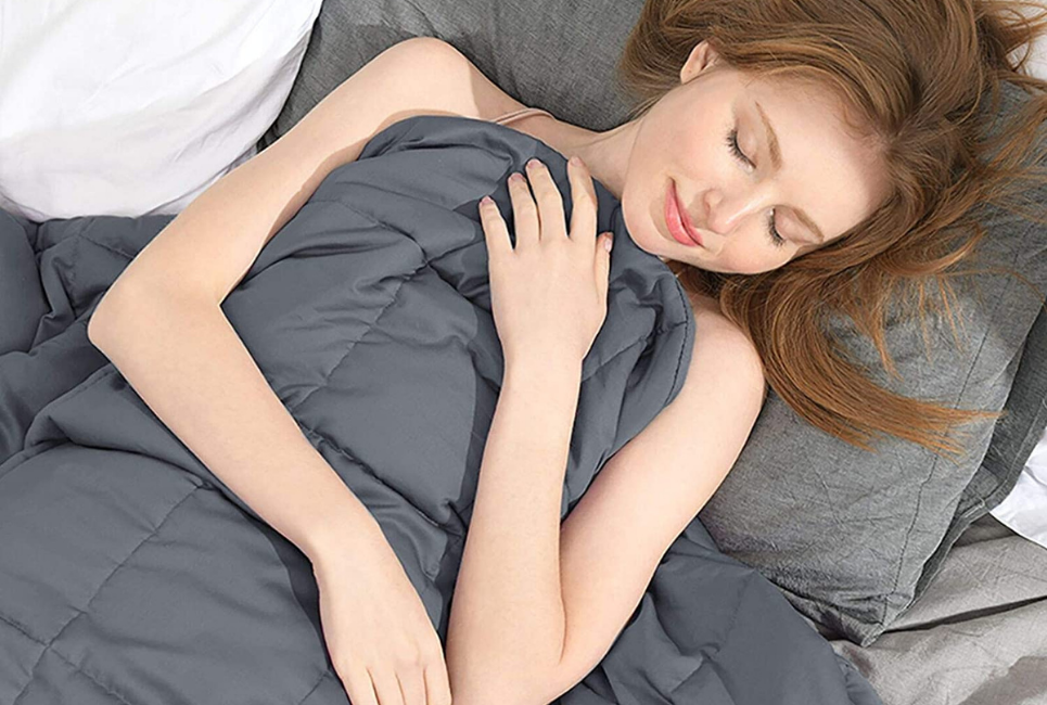 woman sleeping peacefully holding dark grey blanket over her