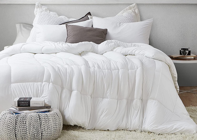 White unmade bed with cozy white comforter in trendy bedroom