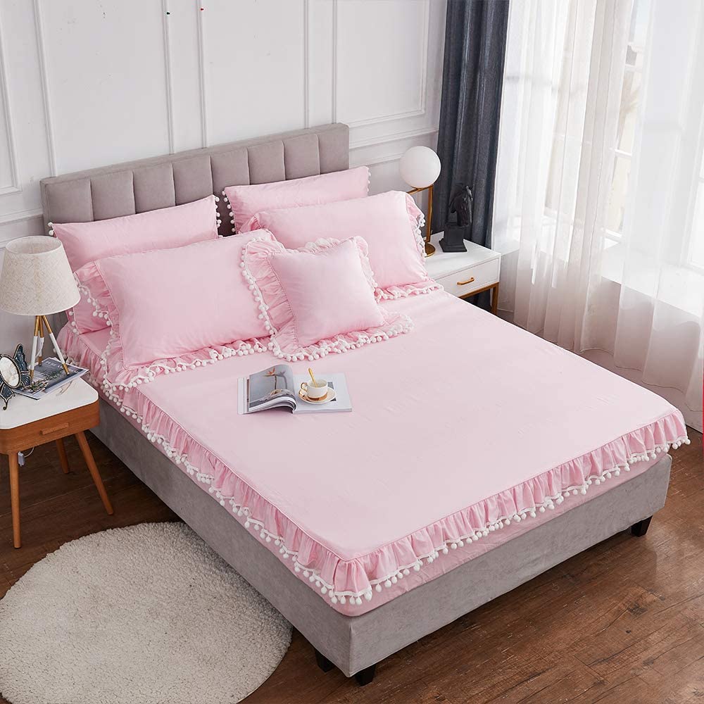 pink sheets on bed with pom pom detail