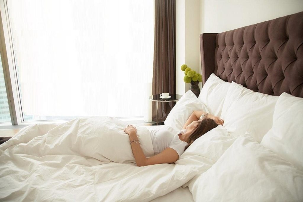 woman sleeping peacefully in bed with white bedding