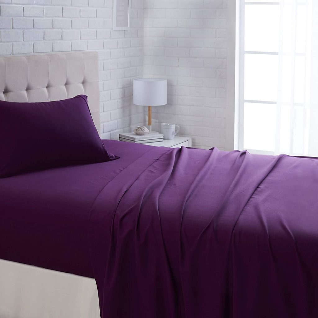 deep purple sheets on bed in clean room