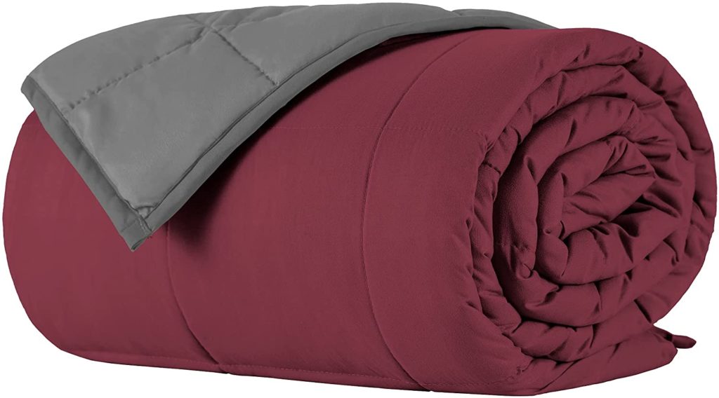 grey and burgundy reversible blanket rolled up neatly