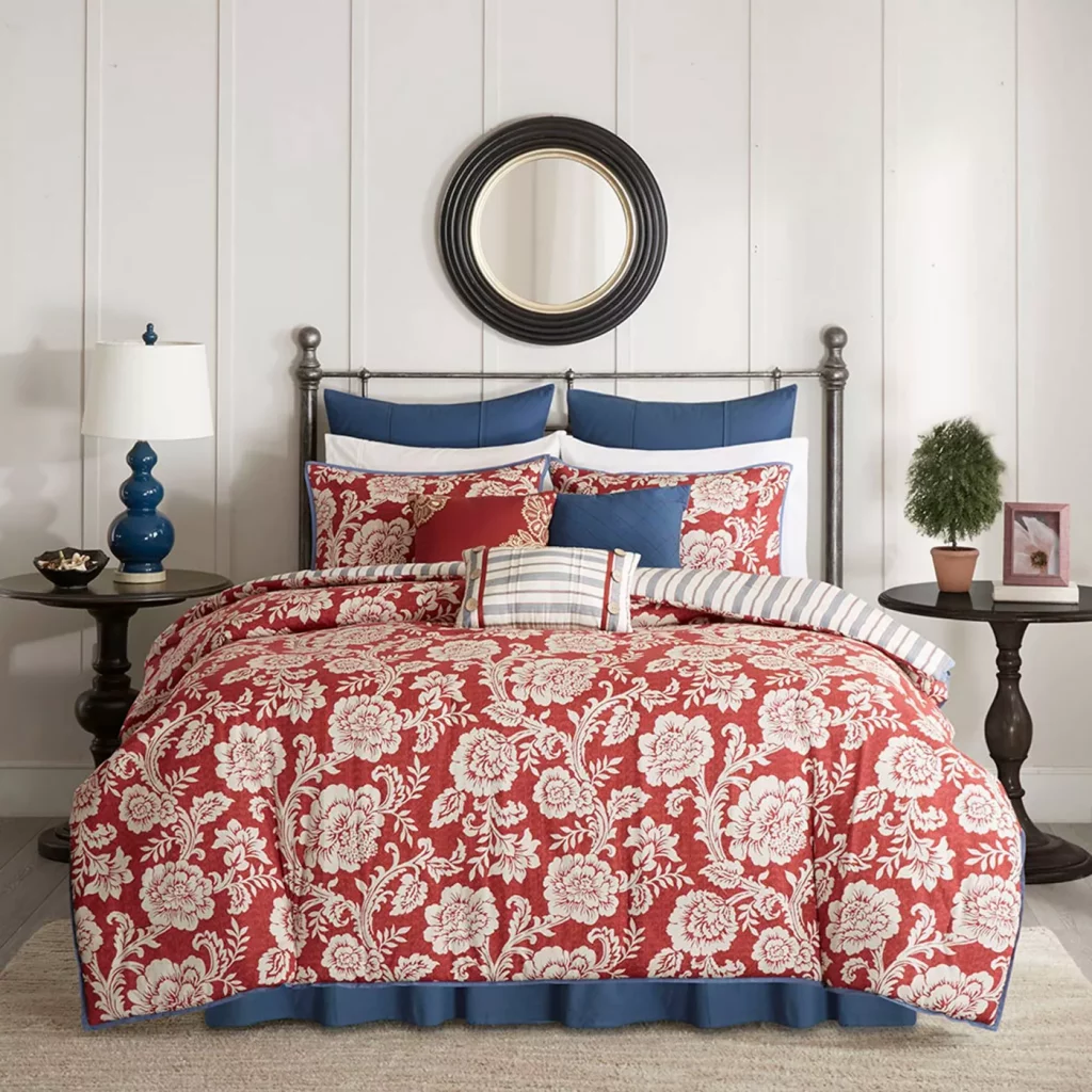 red floral pattern comforter with blue pillows on bed in cozy bedroom