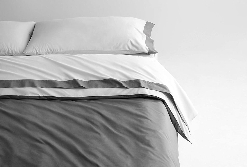 close up of white and grey modern neatly made bed