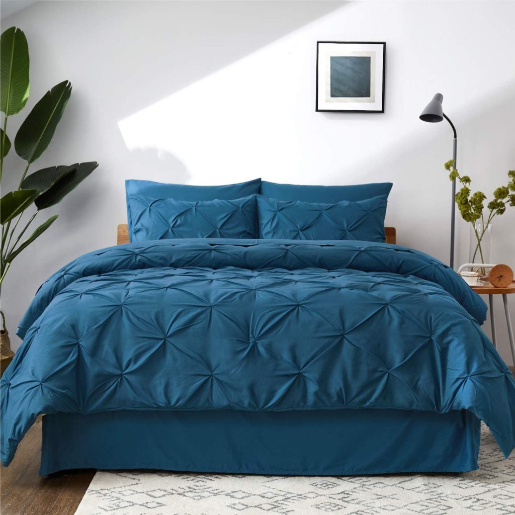 bed made with pinch pleat teal comforter and pillows