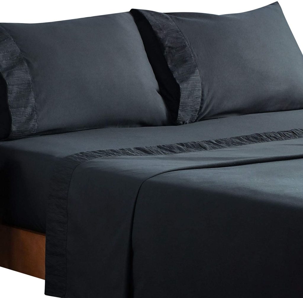 black sheets on bed with textured trim