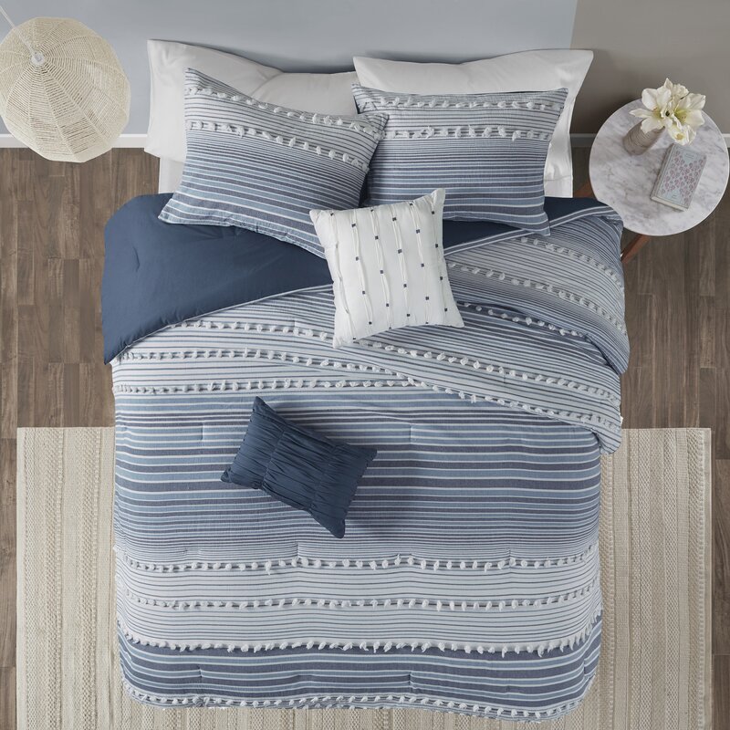 blue and white striped boho comforter with pom pom details