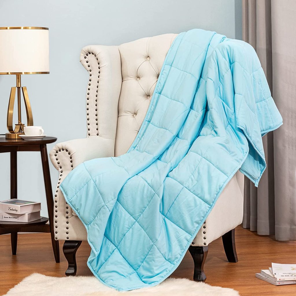 blue quilted banket draped over sitting chair