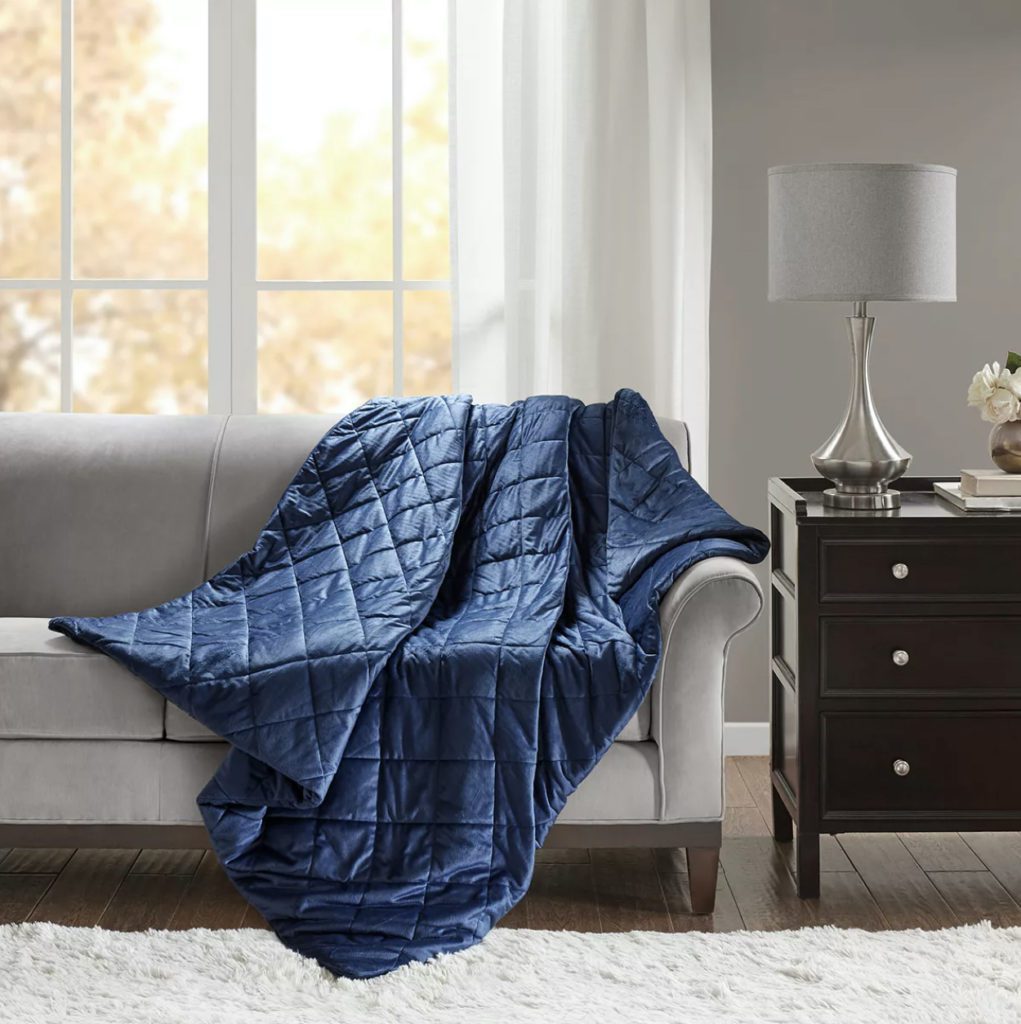 blue weighted blanket draped over couch