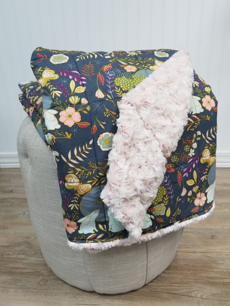 colorful floral print and sherpa reversible blanket draped on chair
