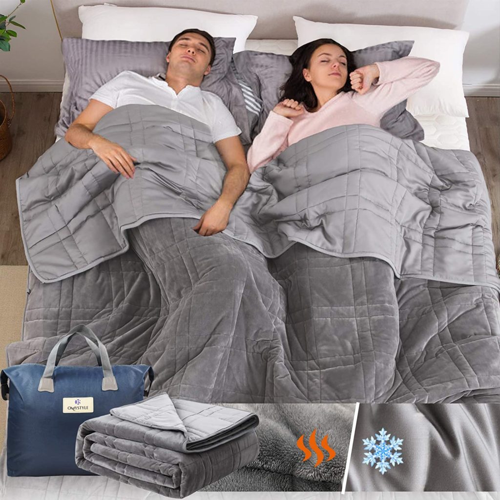couple sleeping peacefully in bed under grey blanket