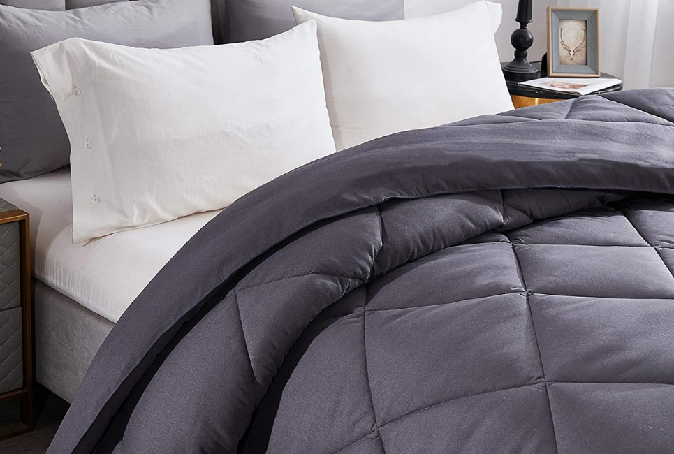 dark grey comforter on bed with white sheets