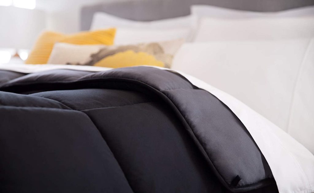 focused image of corner of reversible comforter on bed