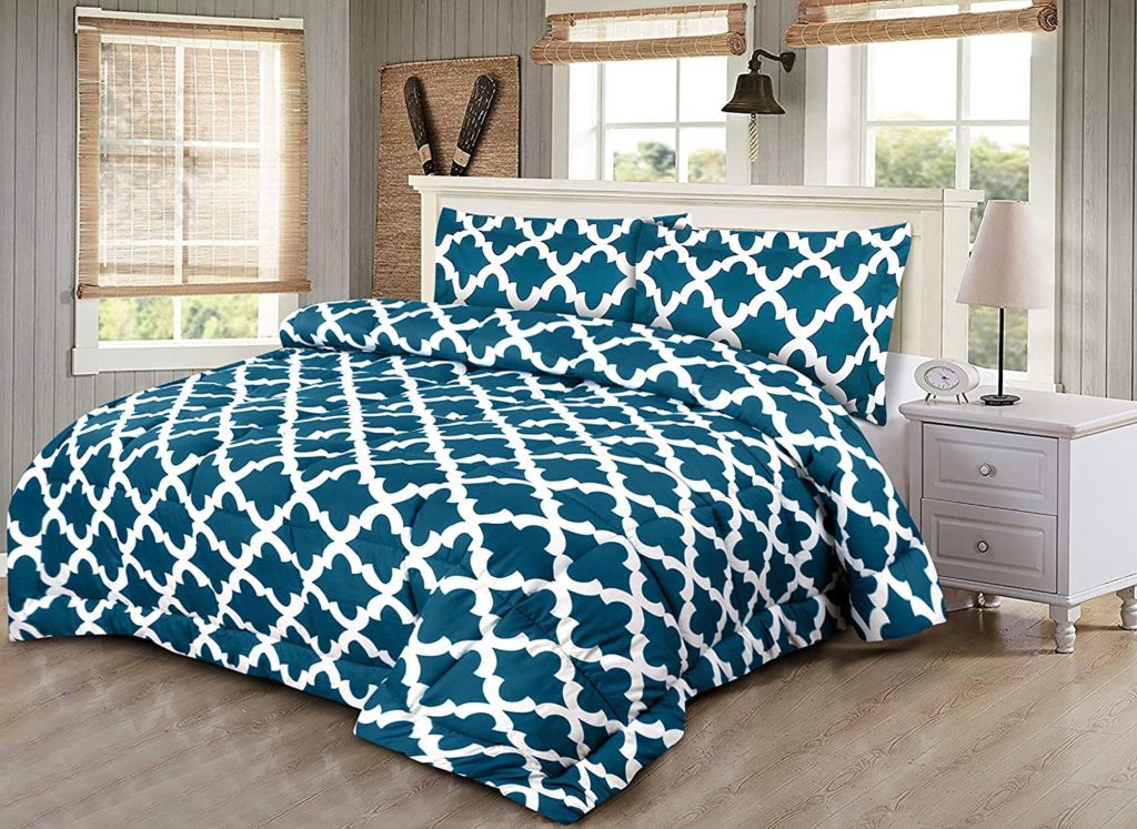 geometric teal and white comforter on bed