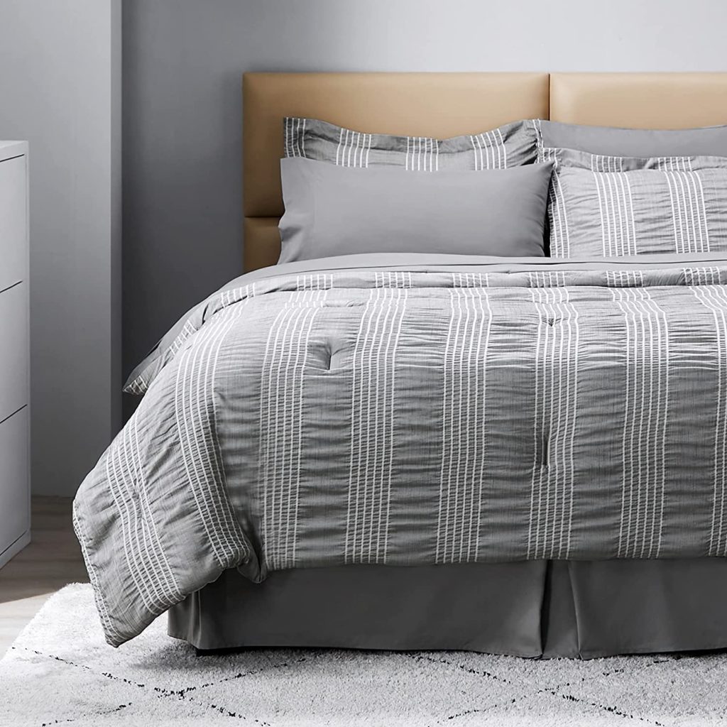 grey bedding on bed with white stripes