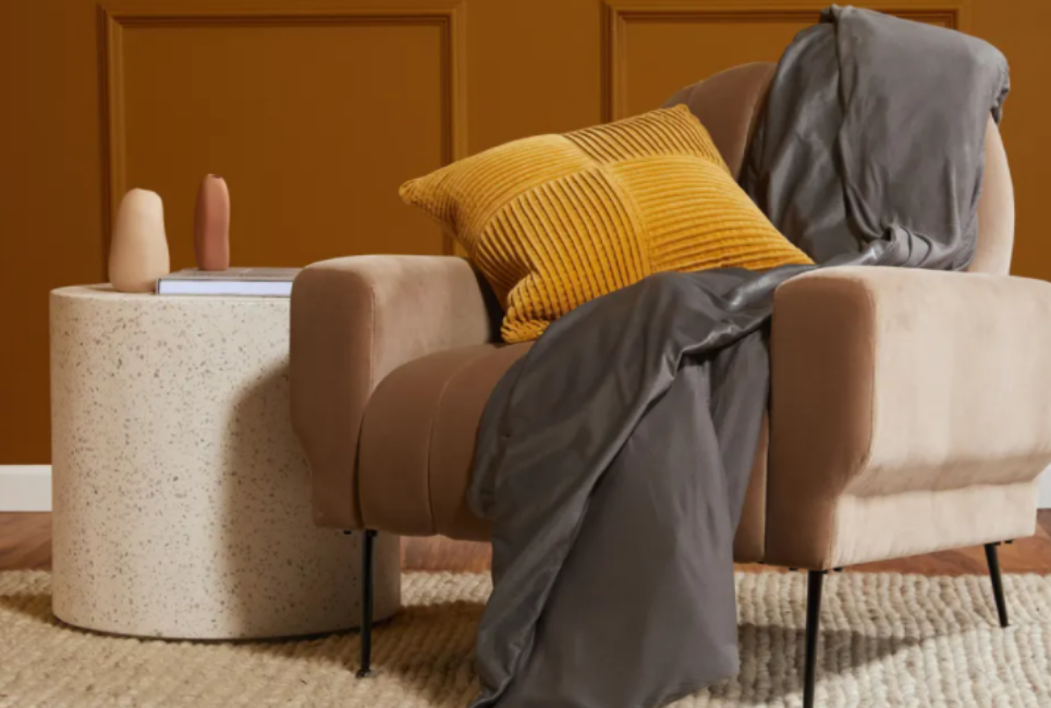 grey blanket draped over modern chair