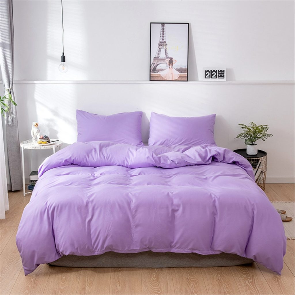 lavender purple comforter on bed in trendy room