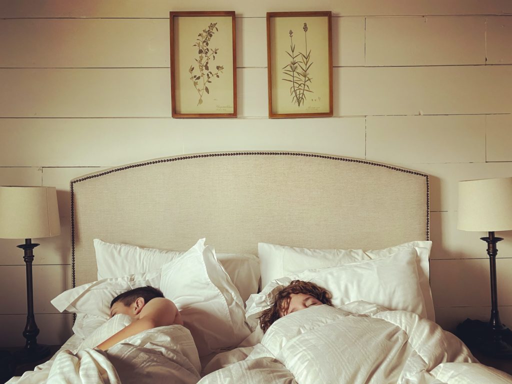 couple sleeping in bed with cream bedding