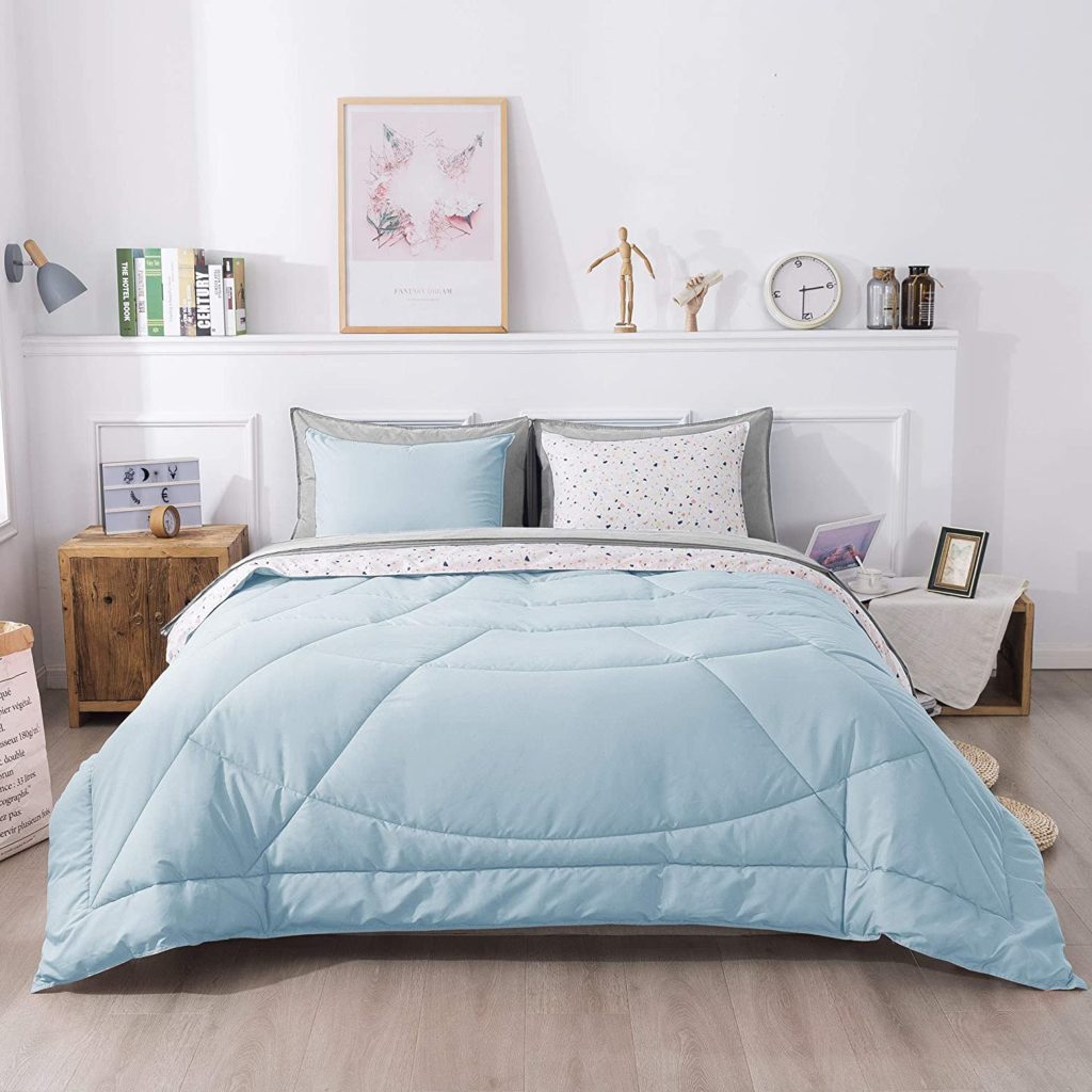 light blue comforter on bed in colorful pastel styled room