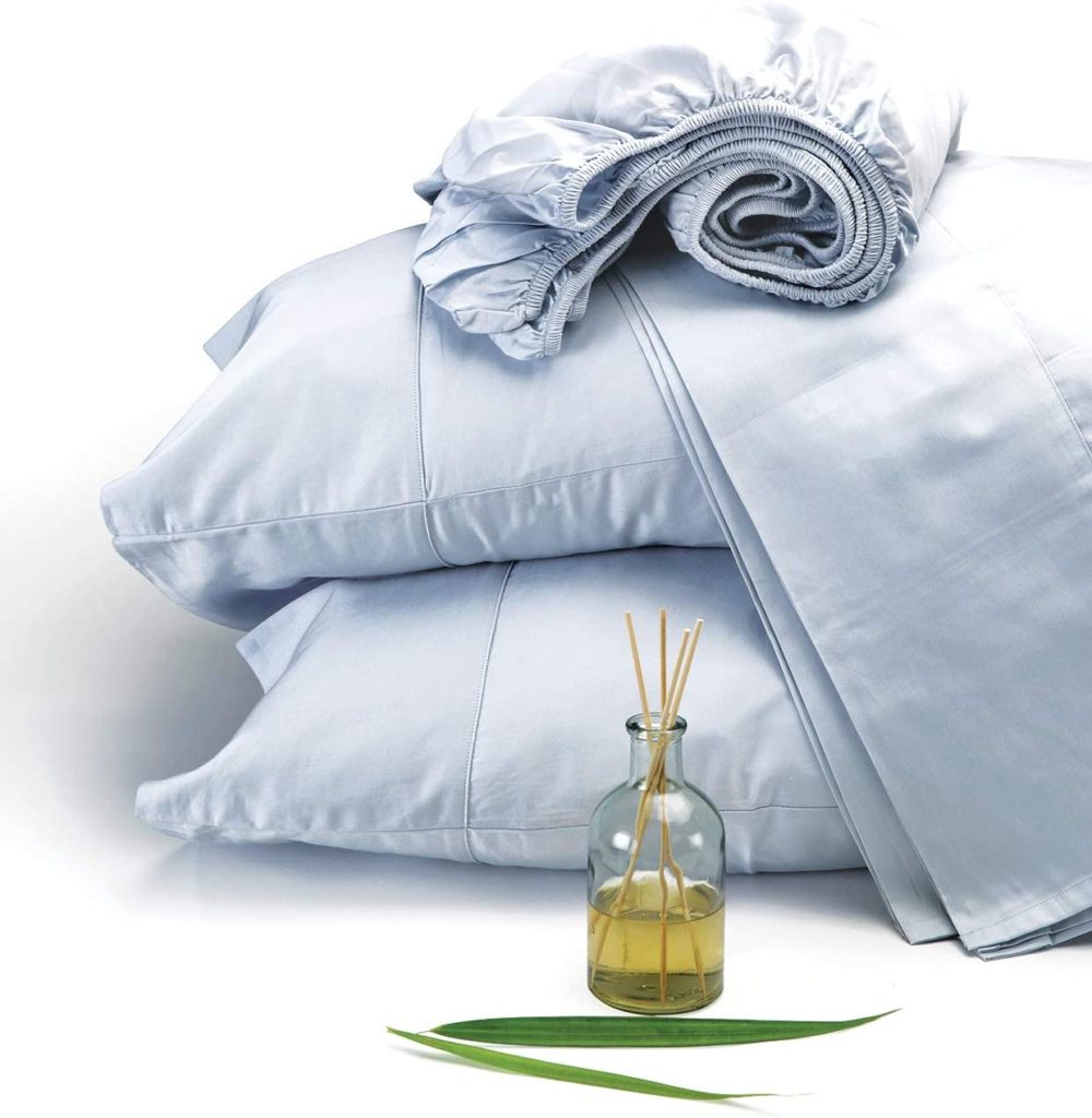 light blue sheet set and pillows stacked with essential oil diffuser