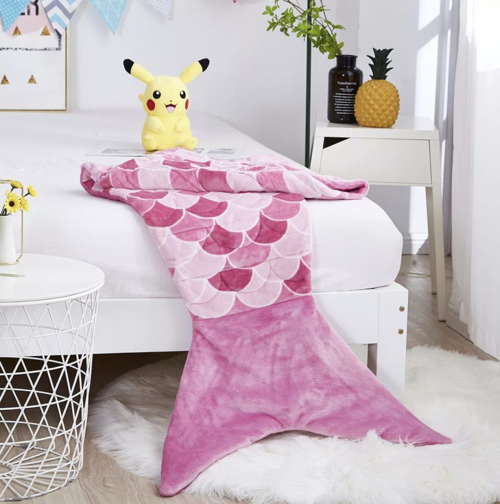 mermaid tail pink weighted blanket on bed with pikachu toy