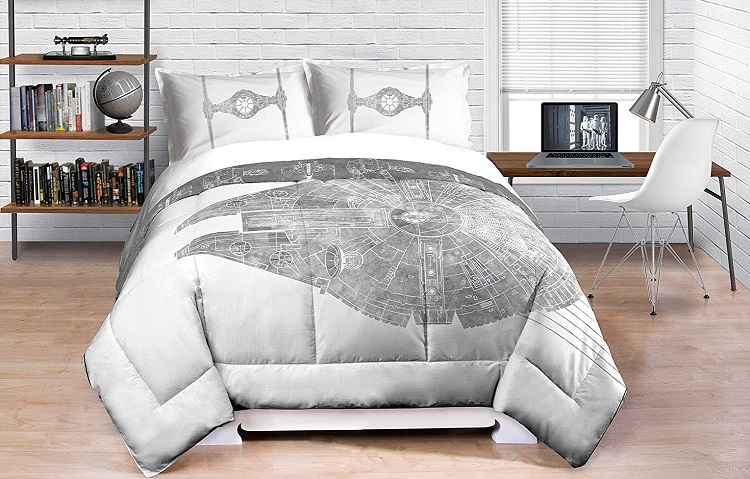 millenium falcon comforter on bed in room with working desk next to bed