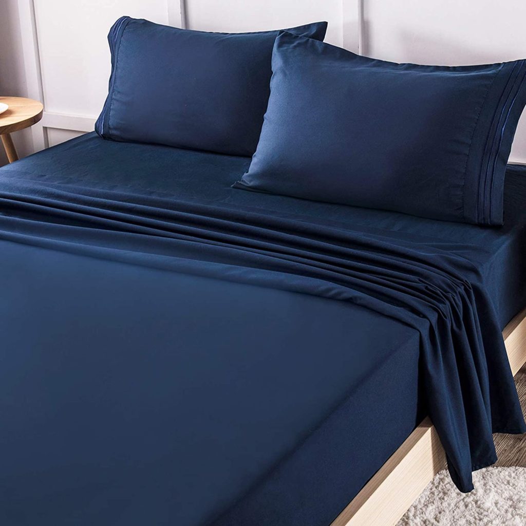 navy blue sheets on neatly made bed